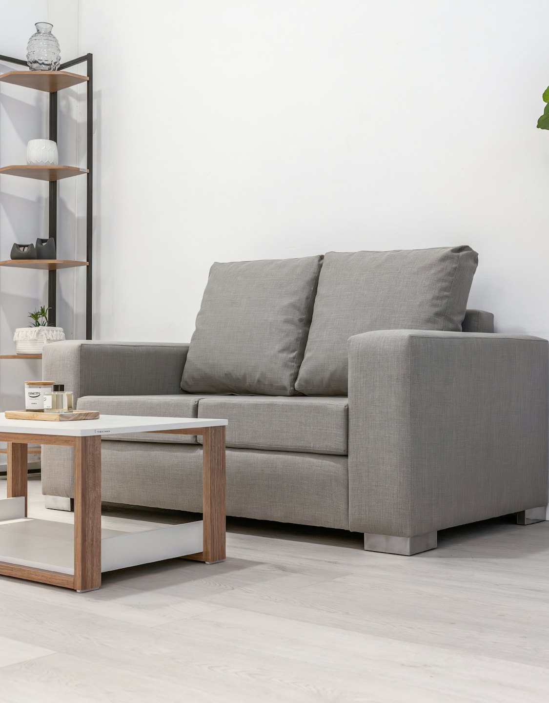 A grey sofa and wooden coffee table in a room.